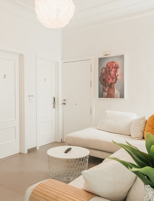 Sala blanca con sofá, mesa de café y planta, ubicada en Salón Condevega, Telde, Gran Canaria